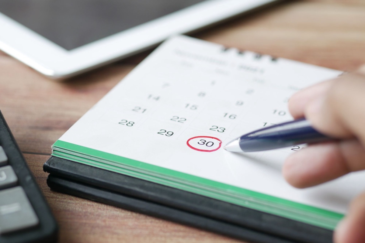 Desk calendar with one date circled in red and a pen.